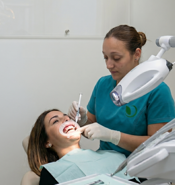 Realizando un tratamiento de blanqueamiento dental clínico profesional con aislamiento protector en Clínica Verna Salud en Molina de Segura.